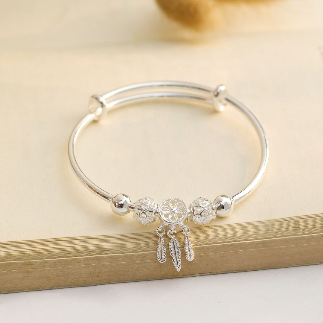Dreamcatcher Bangle on the edge of an open book